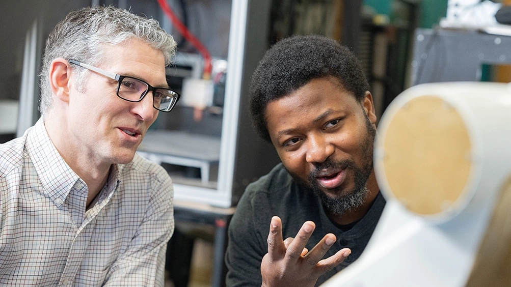 Faculty and student discuss robotic printer.