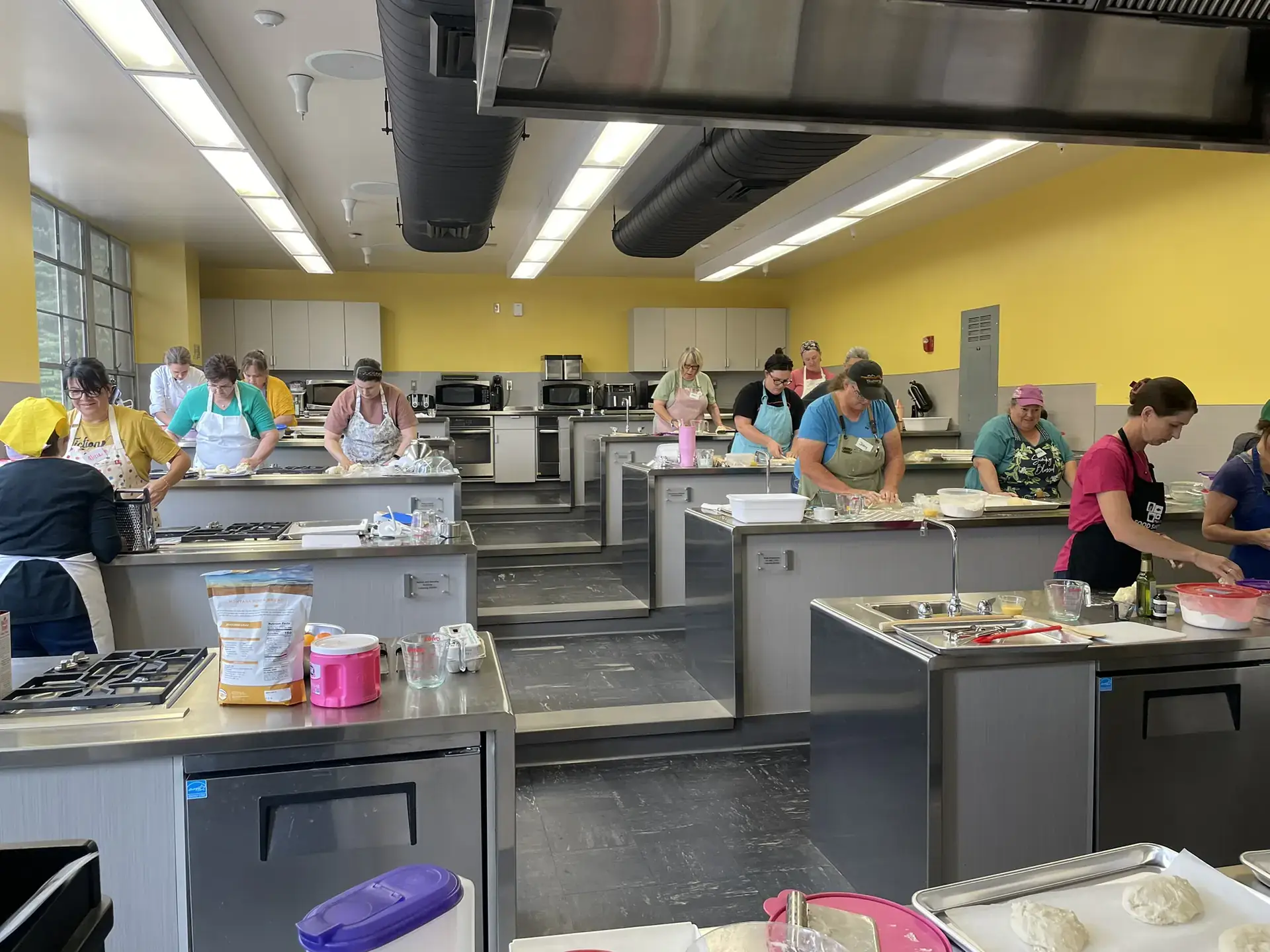 Chefs prepare food at stainless steel tables