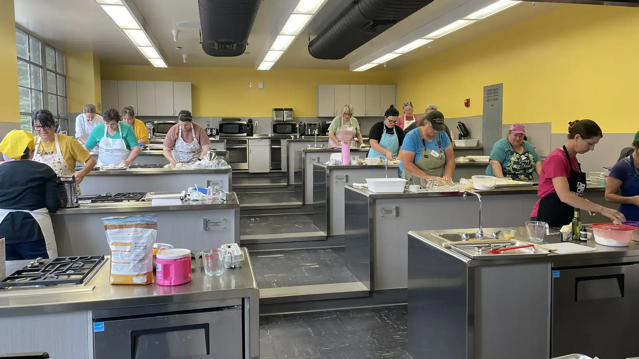 Chefs prepare food at stainless steel tables