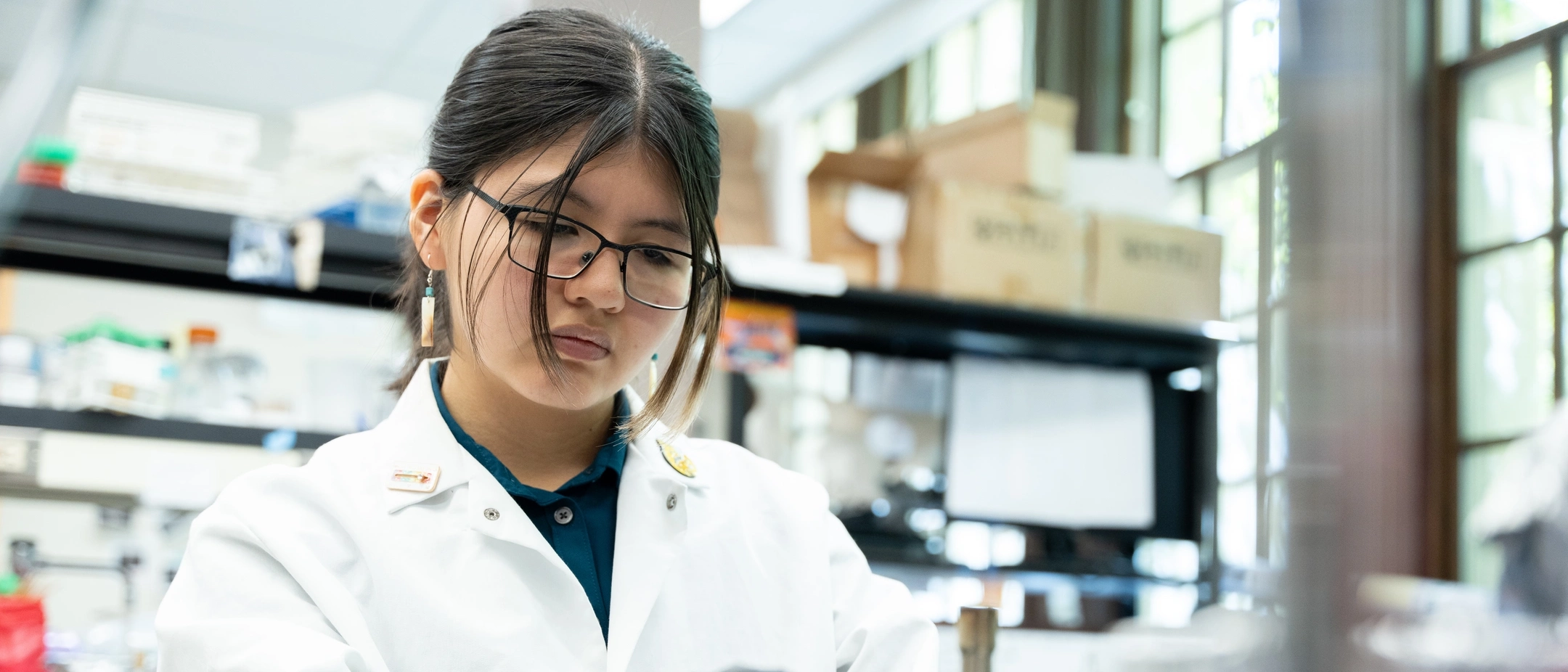 A woman in a lab coat holding a petri dish