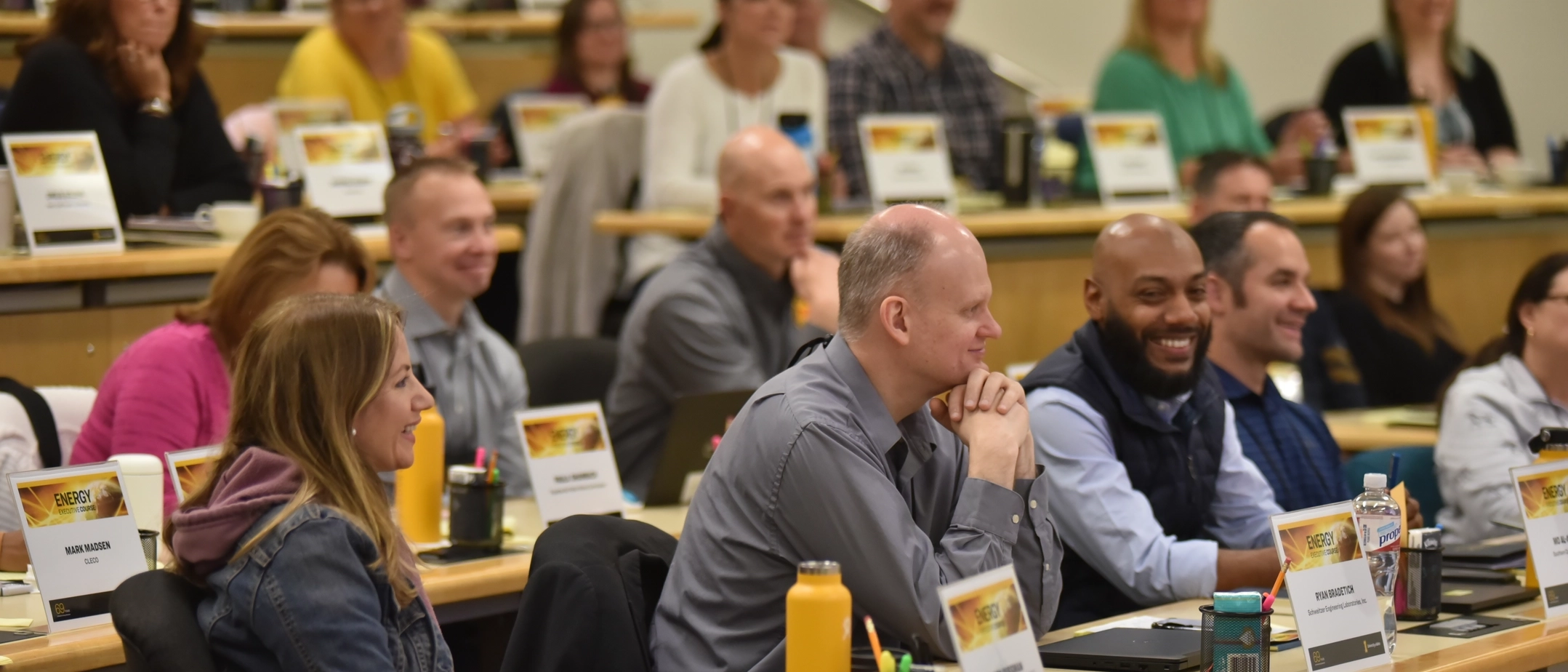 People in a lecture hall smiling and focused