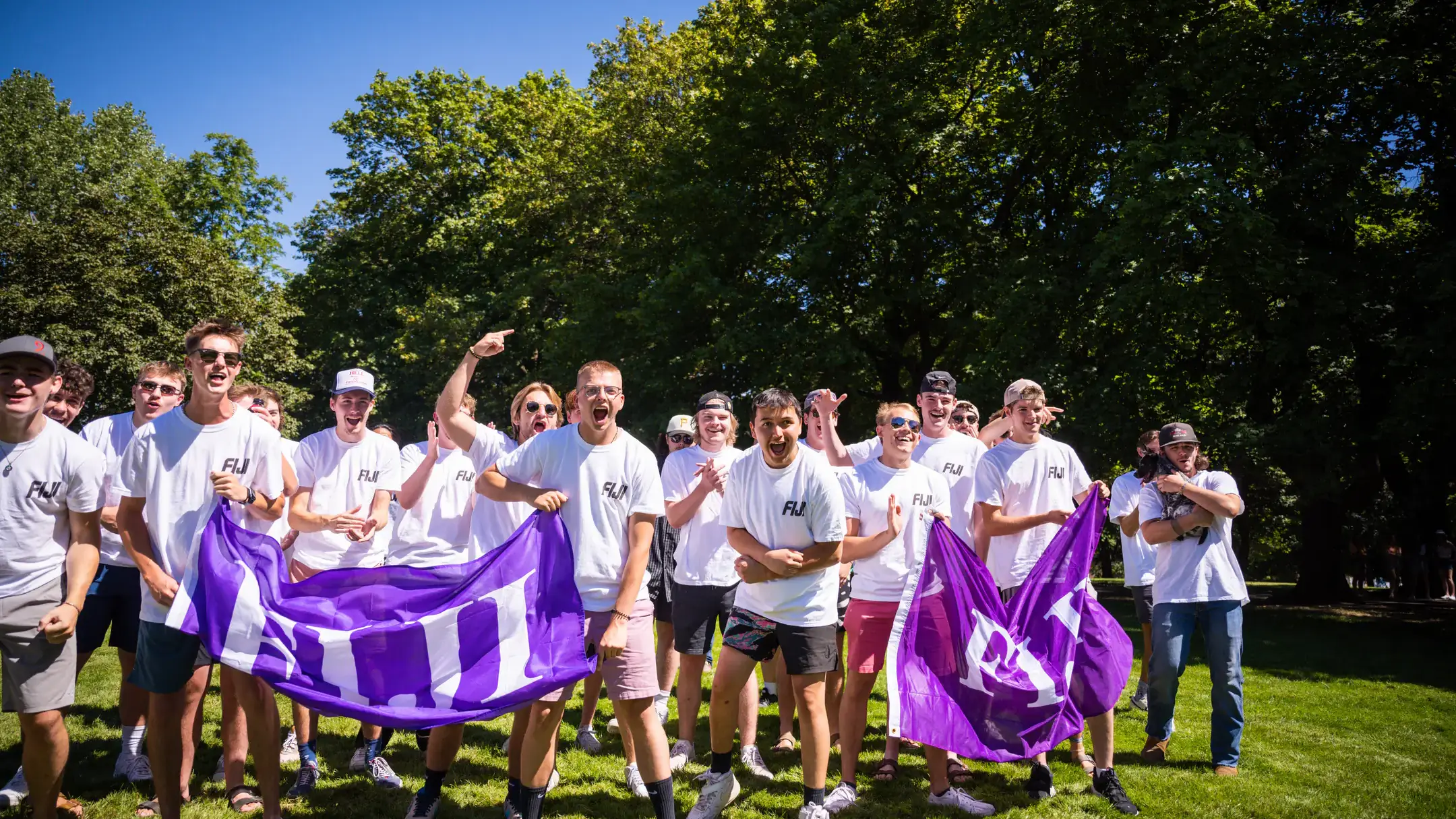 Fraternity brothers holding their chapter's flag.
