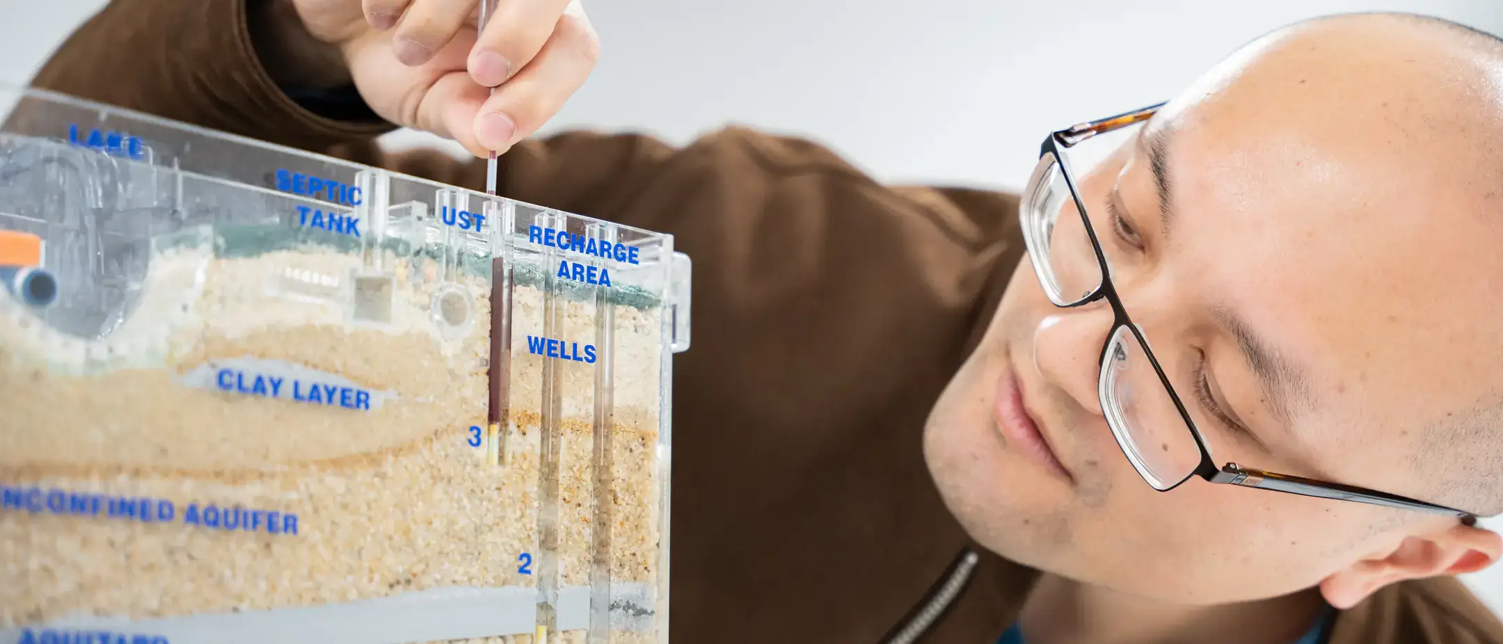 University of Idaho Earth and Spatial Sciences assistant professor  Meng Zhao studies how trees use water in relationship to how much water is available to human beings in relationship with climate change. Here, he is demonstrating a Sand and Gravel ground water Simulator.