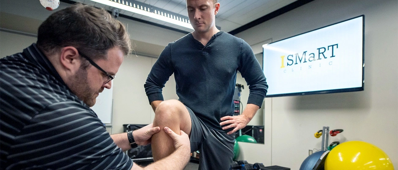 Pre-atheltic training student holding knee in an iSmart clinic setting.