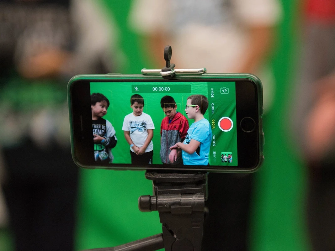 A phone filming four young students.