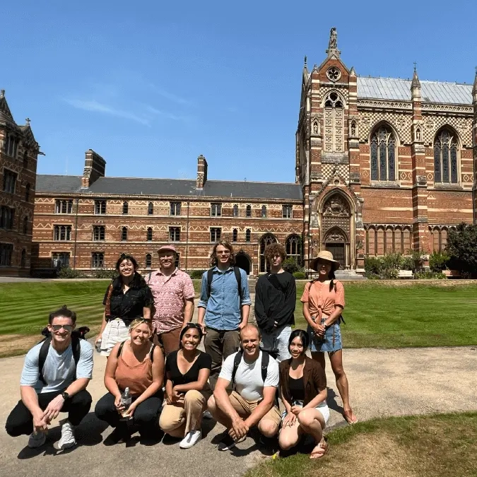 A group of students pose for a picture in front of Keble College, University of Oxford. 