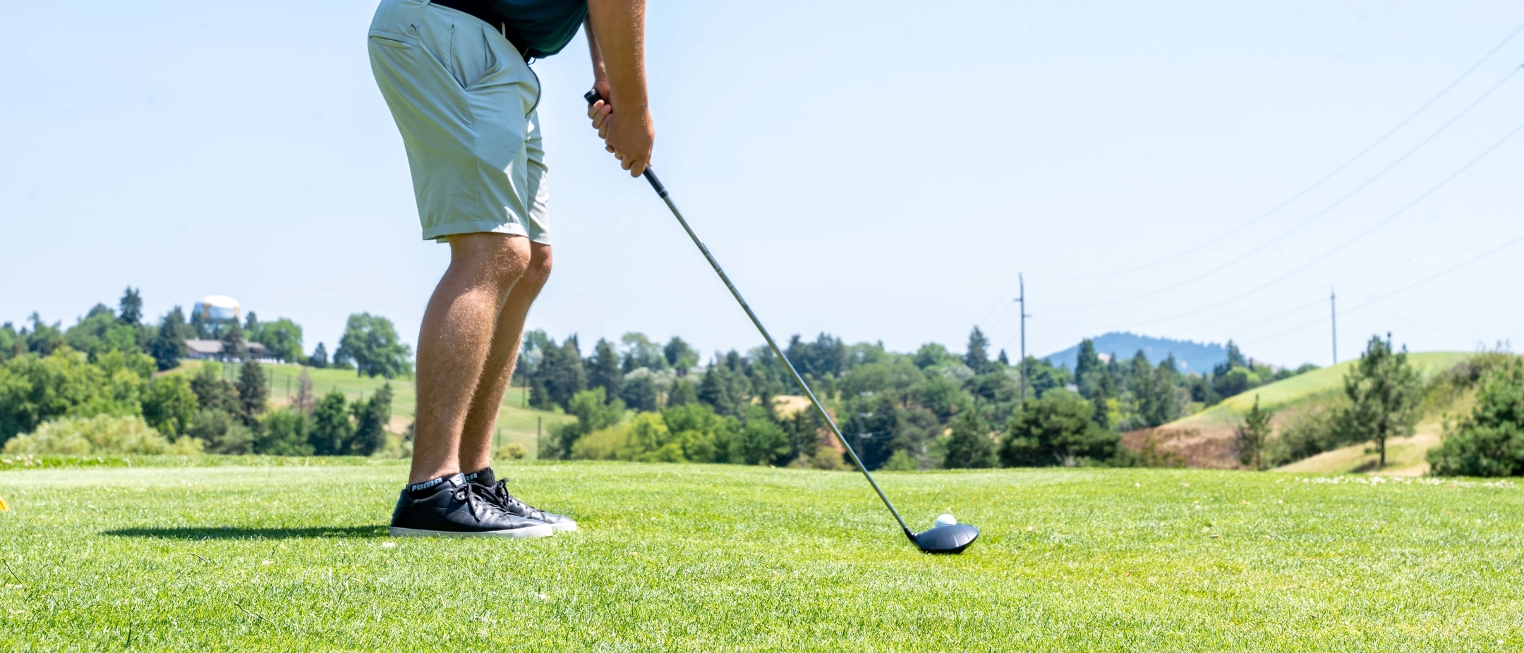 person on golf course lining up driver for a shot
