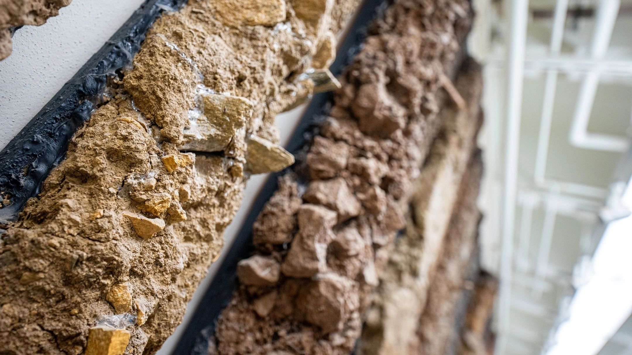 Columns of soil mounted on a wall.