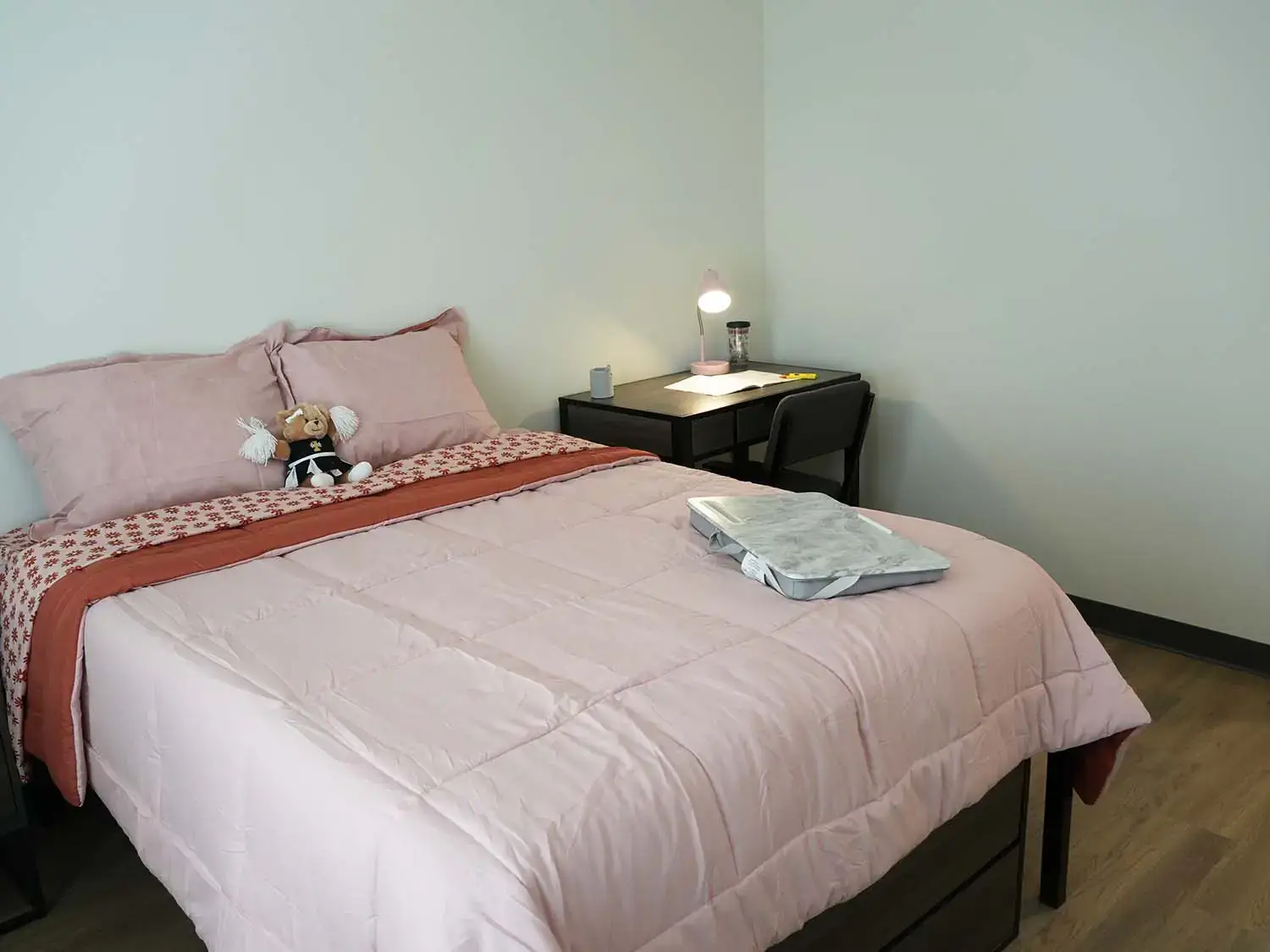Secondary bedroom in a Vandal Village Family Housing apartment with a full-size bed, study desk, and bedside furniture.