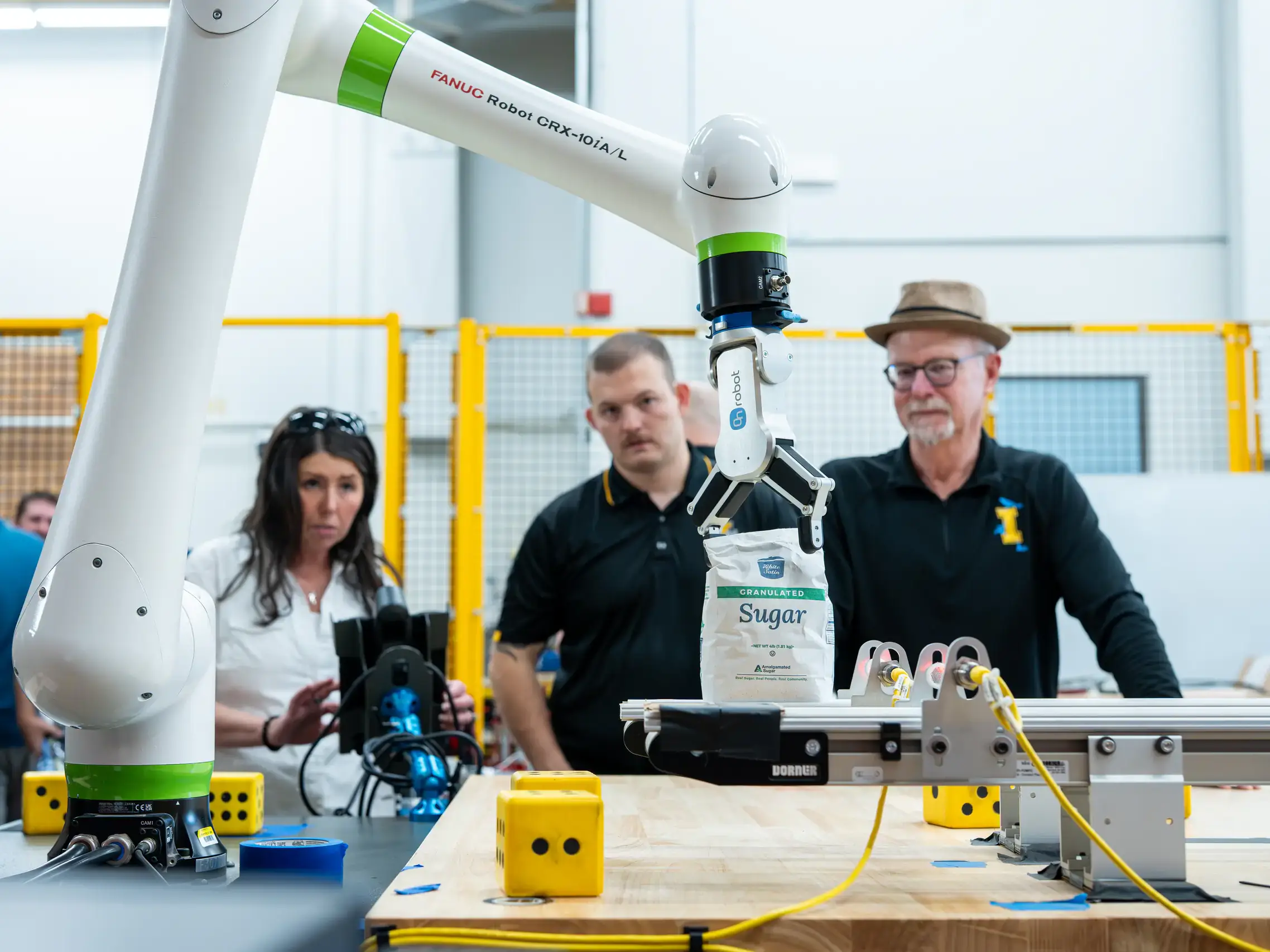 Engineering students and faculty are developing AI-driven automation solutions for Amalgamated Sugar to keep the plant's assembly line from breaking down while adding components to maintain moisture levels in sugar beets, helping the company improve productivity and optimizing both quality and quantity. Pictured from left are Ph.D. researcher Sarah Davis, computer science graduate student Hunter Hawkins, research faculty John Shovic.