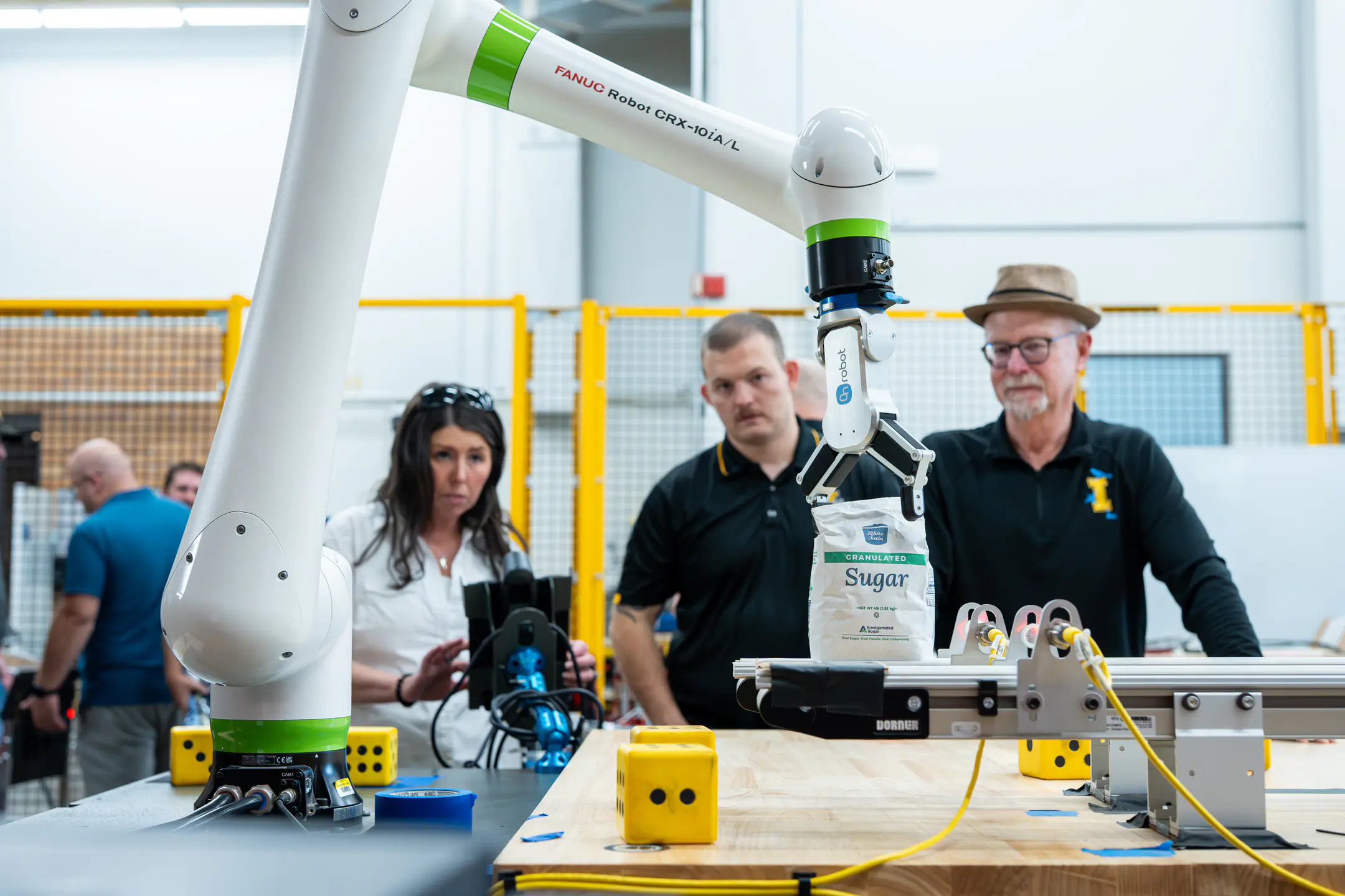 Engineering students and faculty are developing AI-driven automation solutions for Amalgamated Sugar to keep the plant's assembly line from breaking down while adding components to maintain moisture levels in sugar beets, helping the company improve productivity and optimizing both quality and quantity. Pictured from left are Ph.D. researcher Sarah Davis, computer science graduate student Hunter Hawkins, research faculty John Shovic.