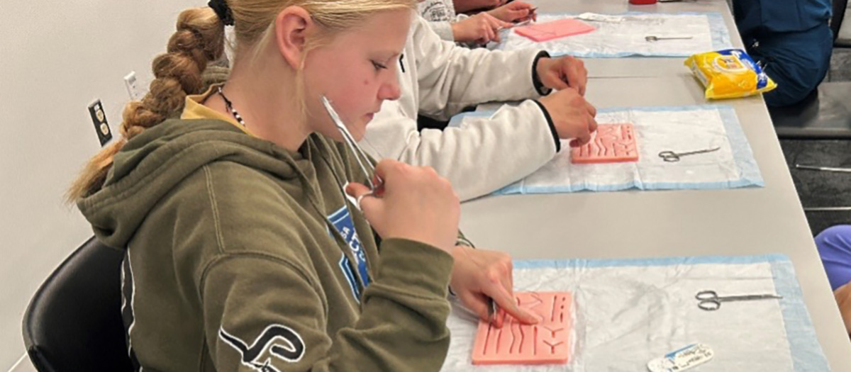 Student learns suturing on a suture mat.