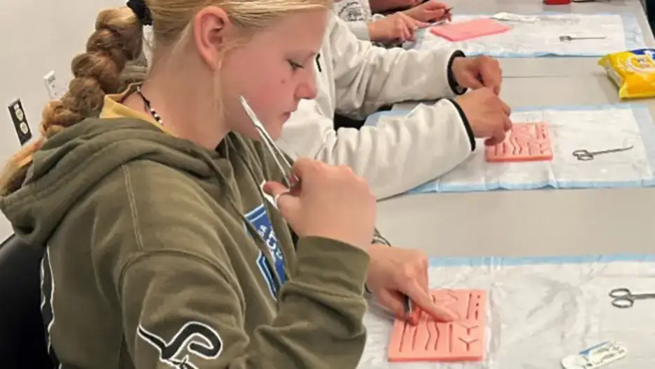 Student learns suturing on a suture mat.
