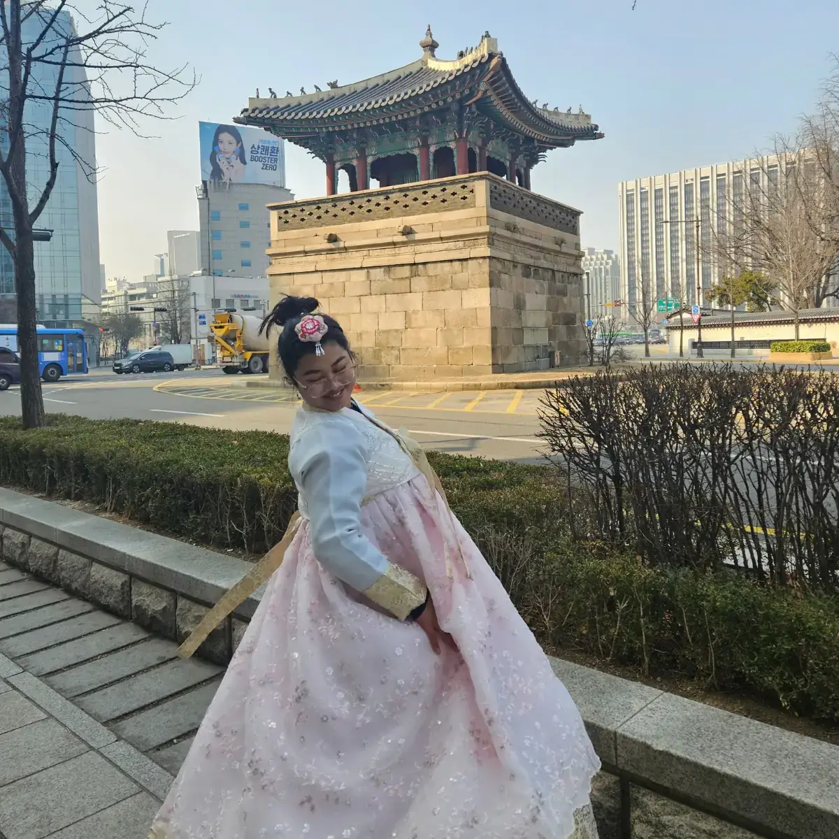 A woman posing in front of a building.