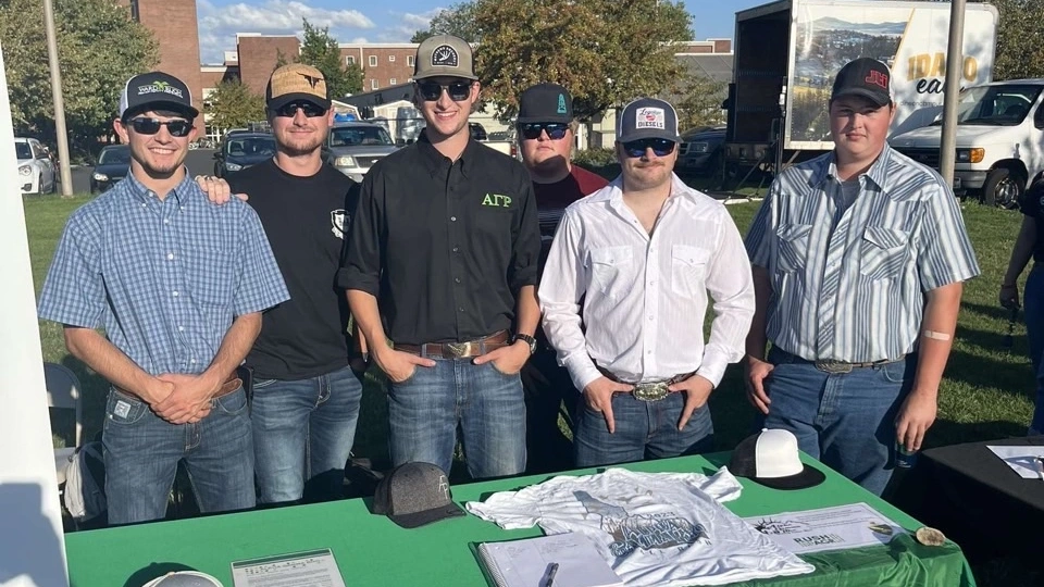 Alpha Gamma Rho members behind their recruiting table