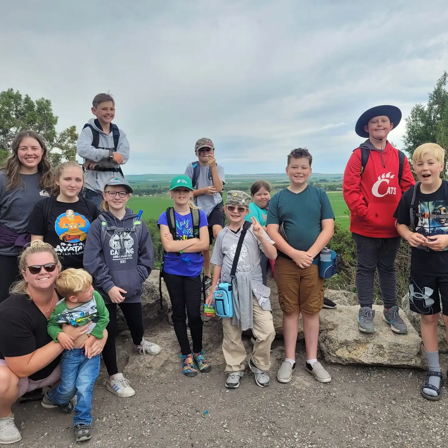 A group of mostly children pose near a point of interest.