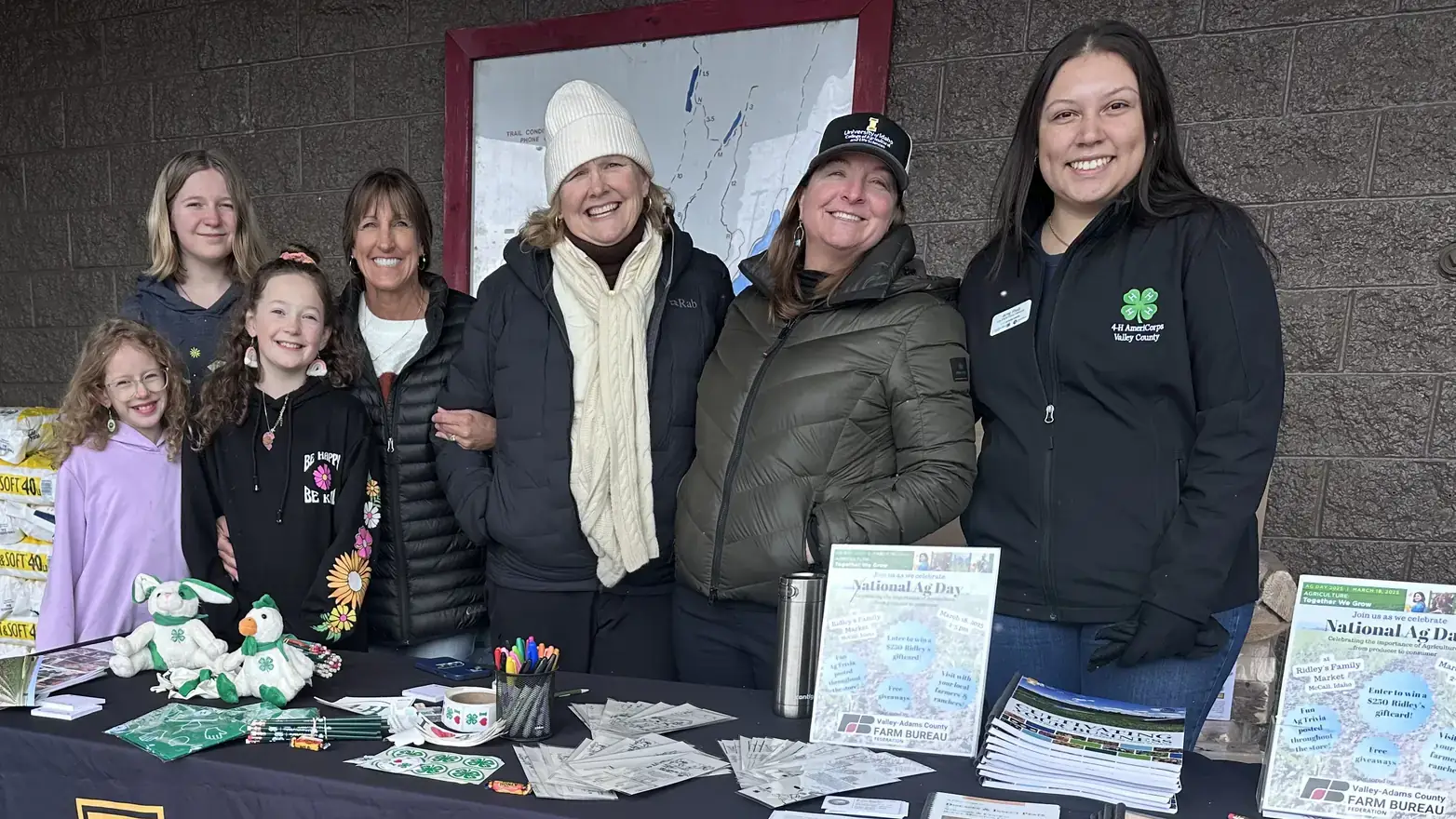 4-H youth and leaders behind the 4-H display table.