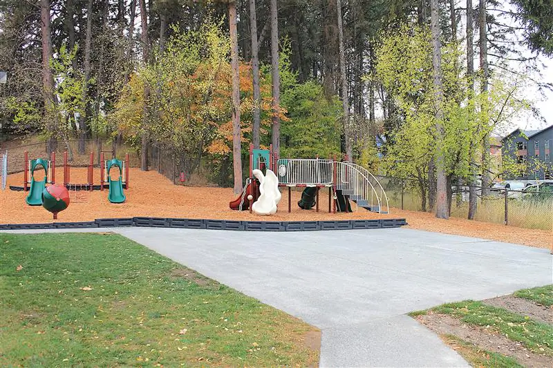 A playground with multiple large jungle gyms and other small outdoor toys.