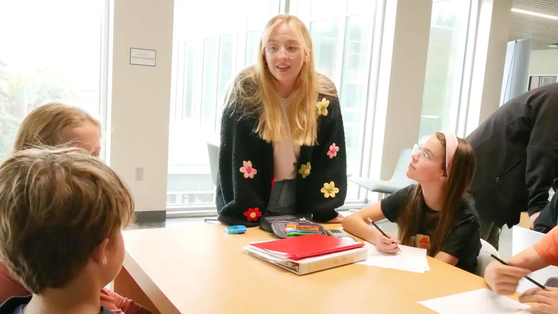A woman talking with children in a classroom.