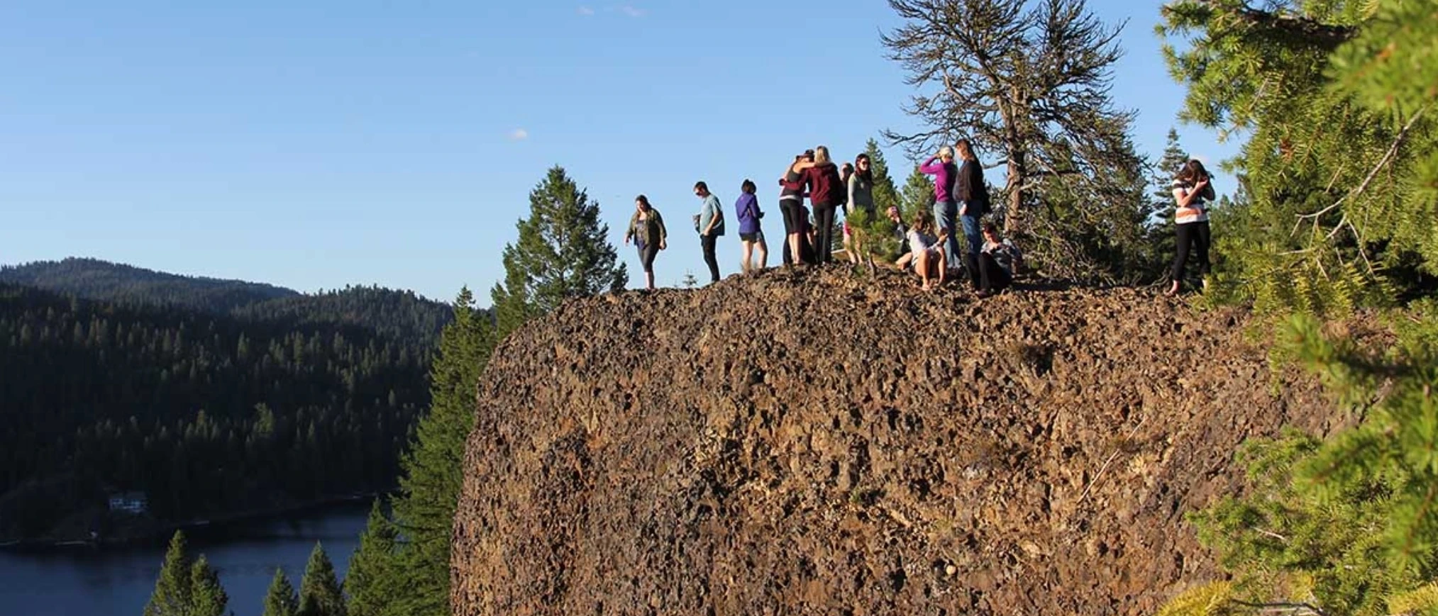 group of students on cliff outside with mountains