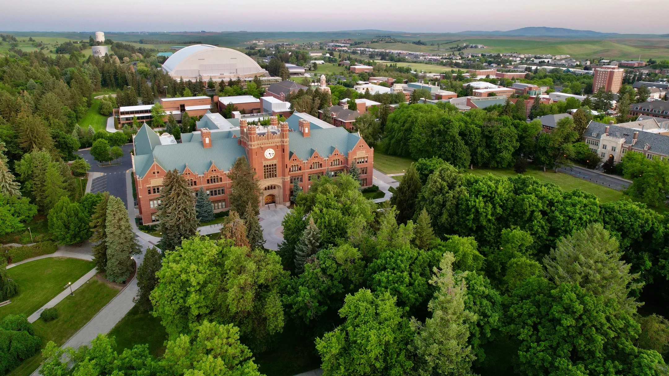 An oblique aerial view drone photograph of the University of Idaho Administration Building and campus in the spring.