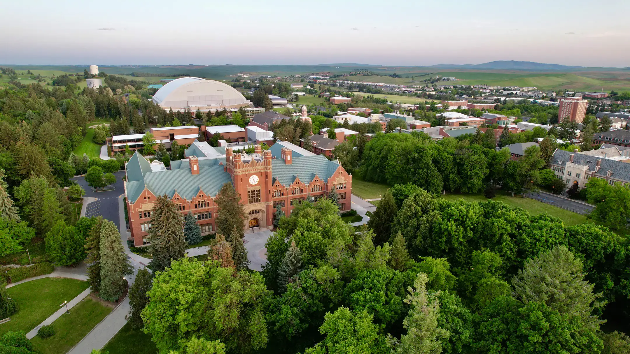 An oblique aerial view drone photograph of the University of Idaho Administration Building and campus in the spring.