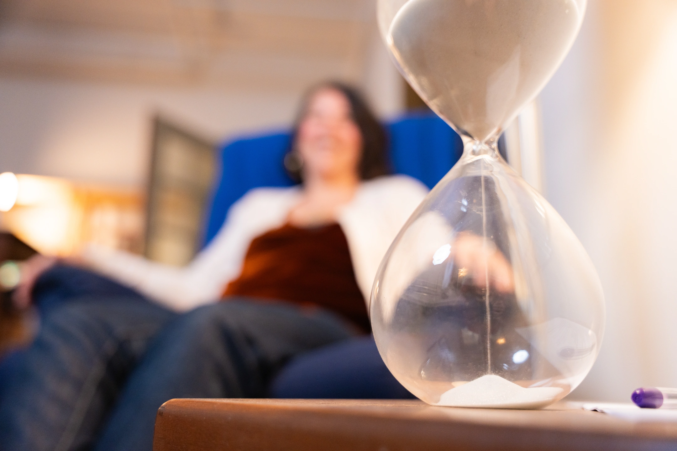 An hourglass with sand falling.