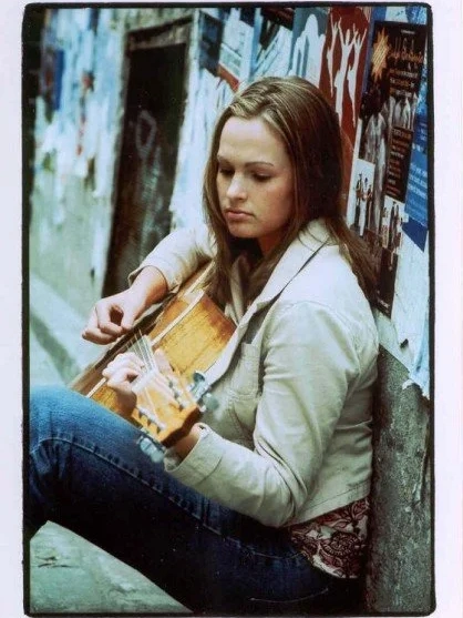 Woman sitting playing guitar