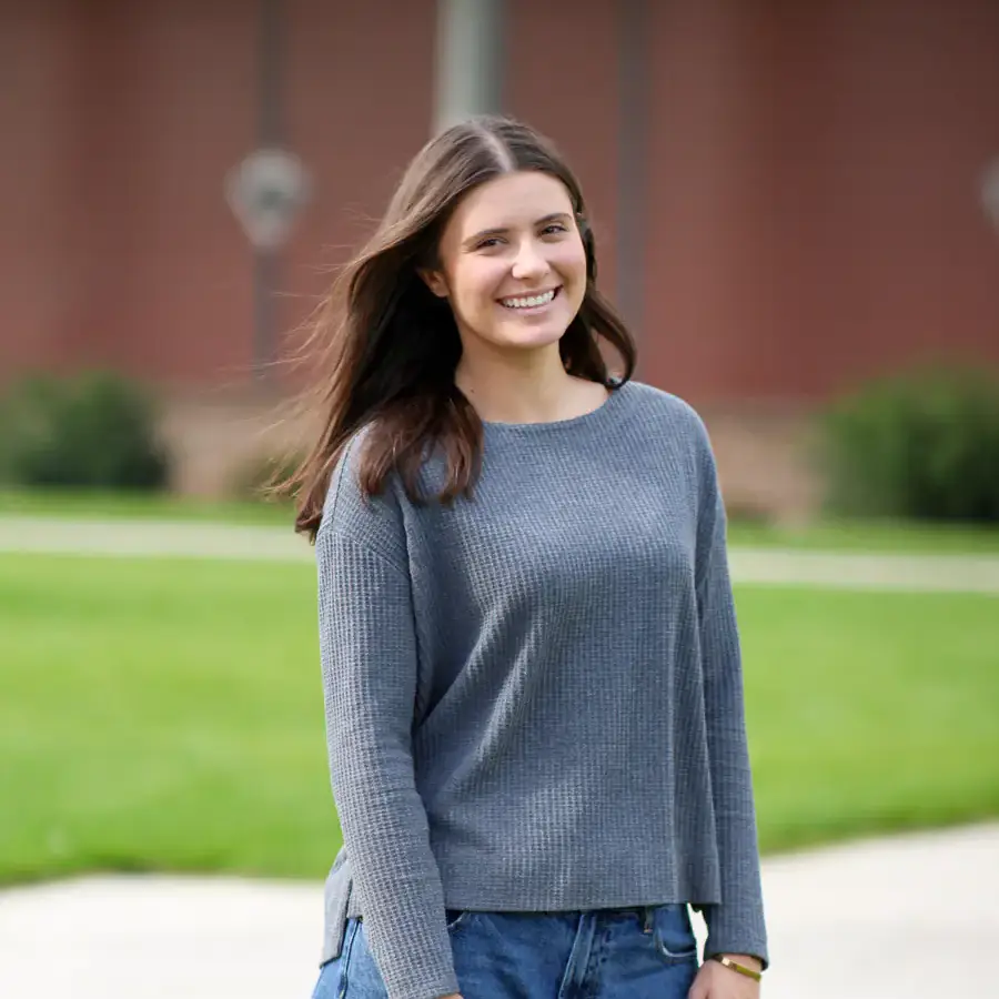 Jessica standing on the lawn in front of the Admin buildng.