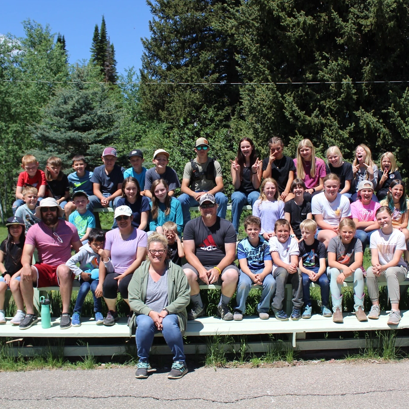 A large group sits on bleachers.