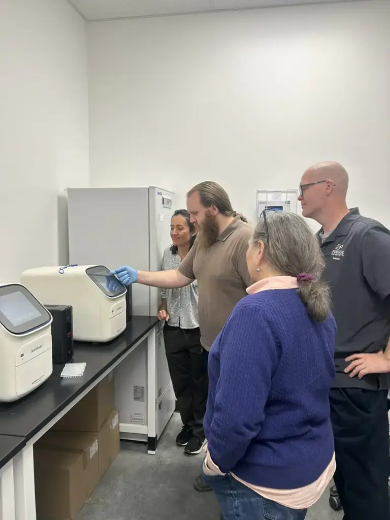 A group of scientists look at laboratory equipment.