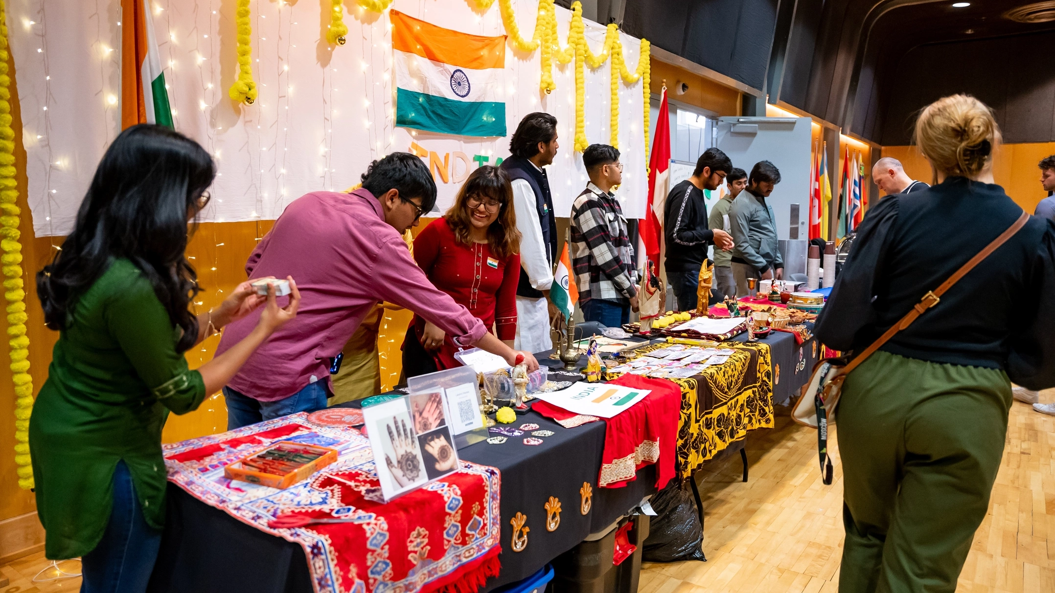 Volunteers smile at booths about their home countries