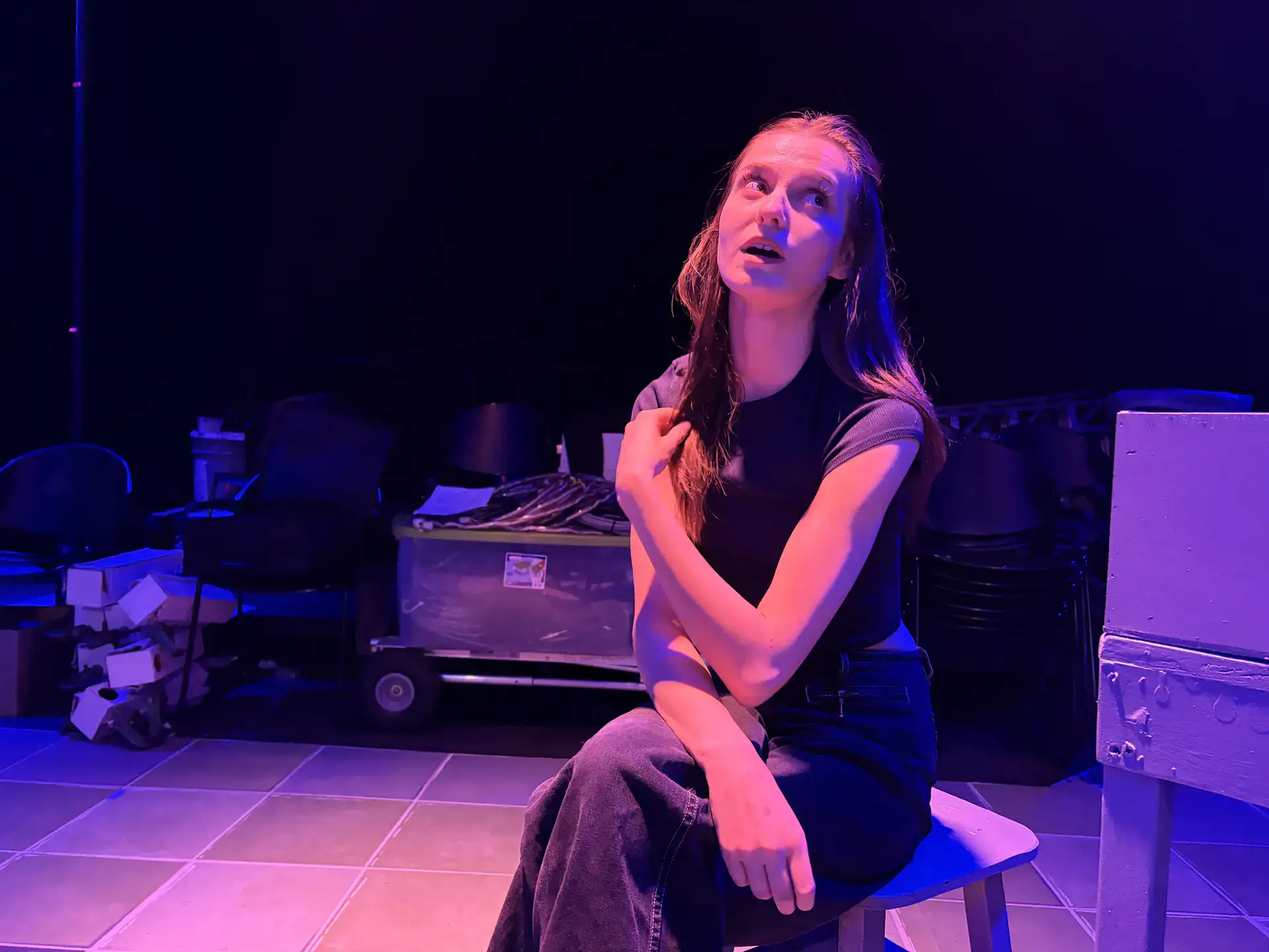 Cambree Miller actor sits on a stool.