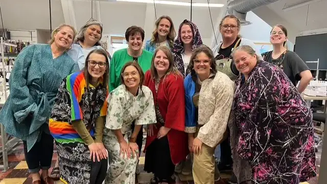 High school family and consumer sciences teachers pose in a group wearing their colorful, handmade zero-waste jackets.