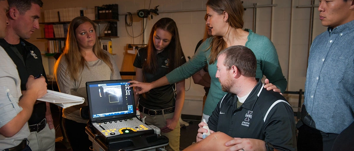 A group of U of I students receiving training on a piece of medical equipment in a lab. 