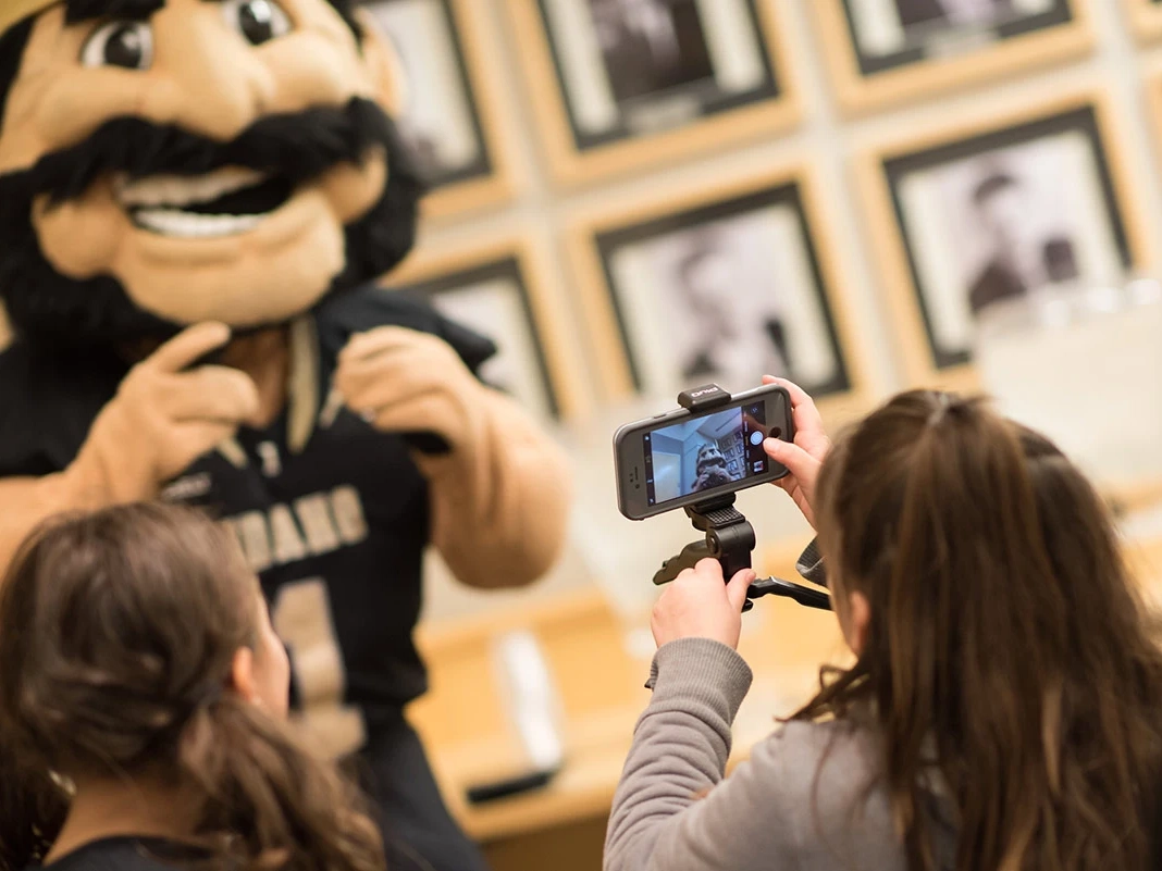 Two young students film Joe Vandal. 