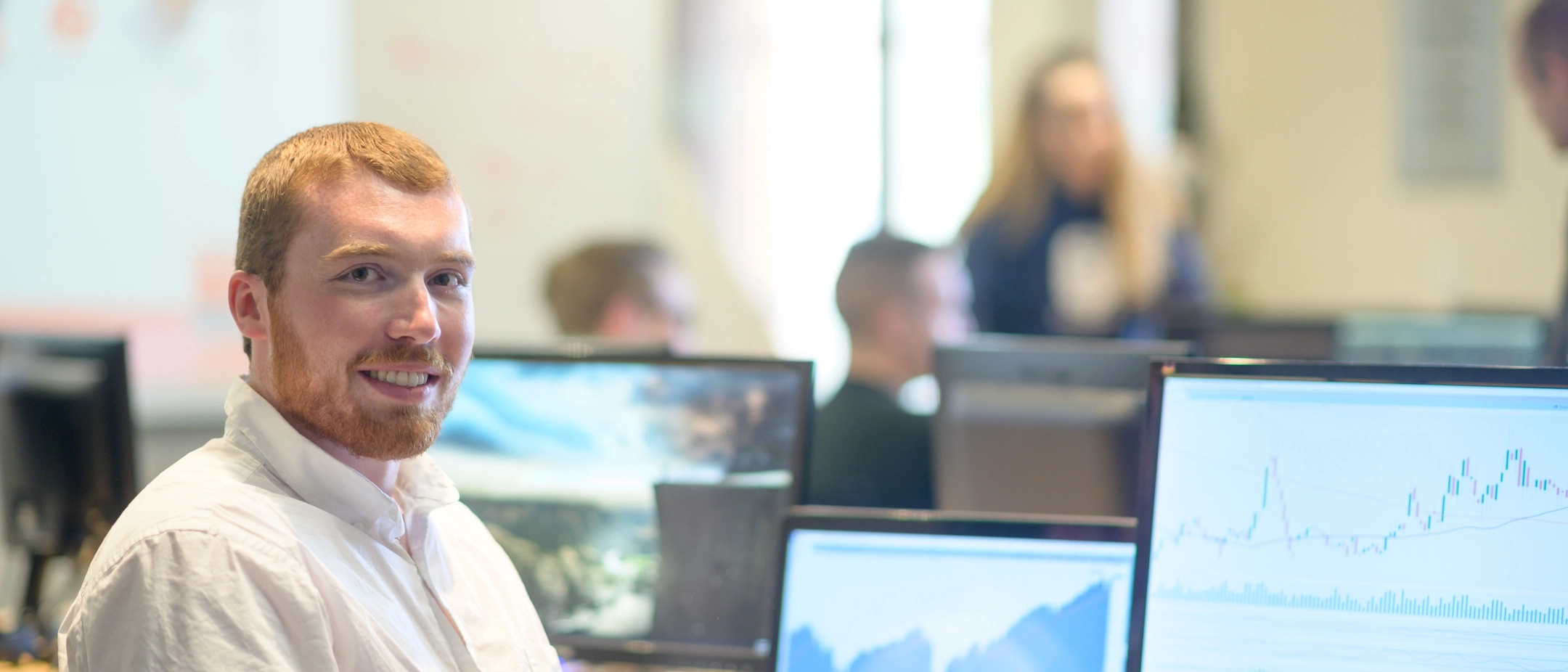 U of I student sitting at a desk looking a financial data in a computer lab. 
