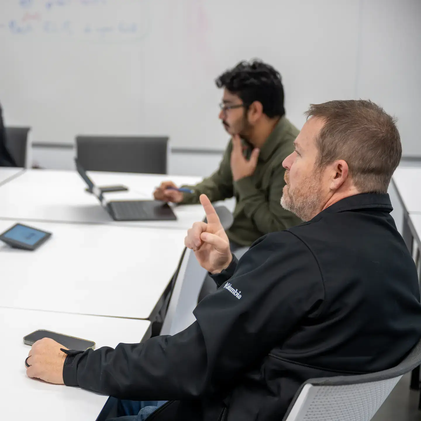Marty Ytreberg and students sitting at a table discussing research data,
