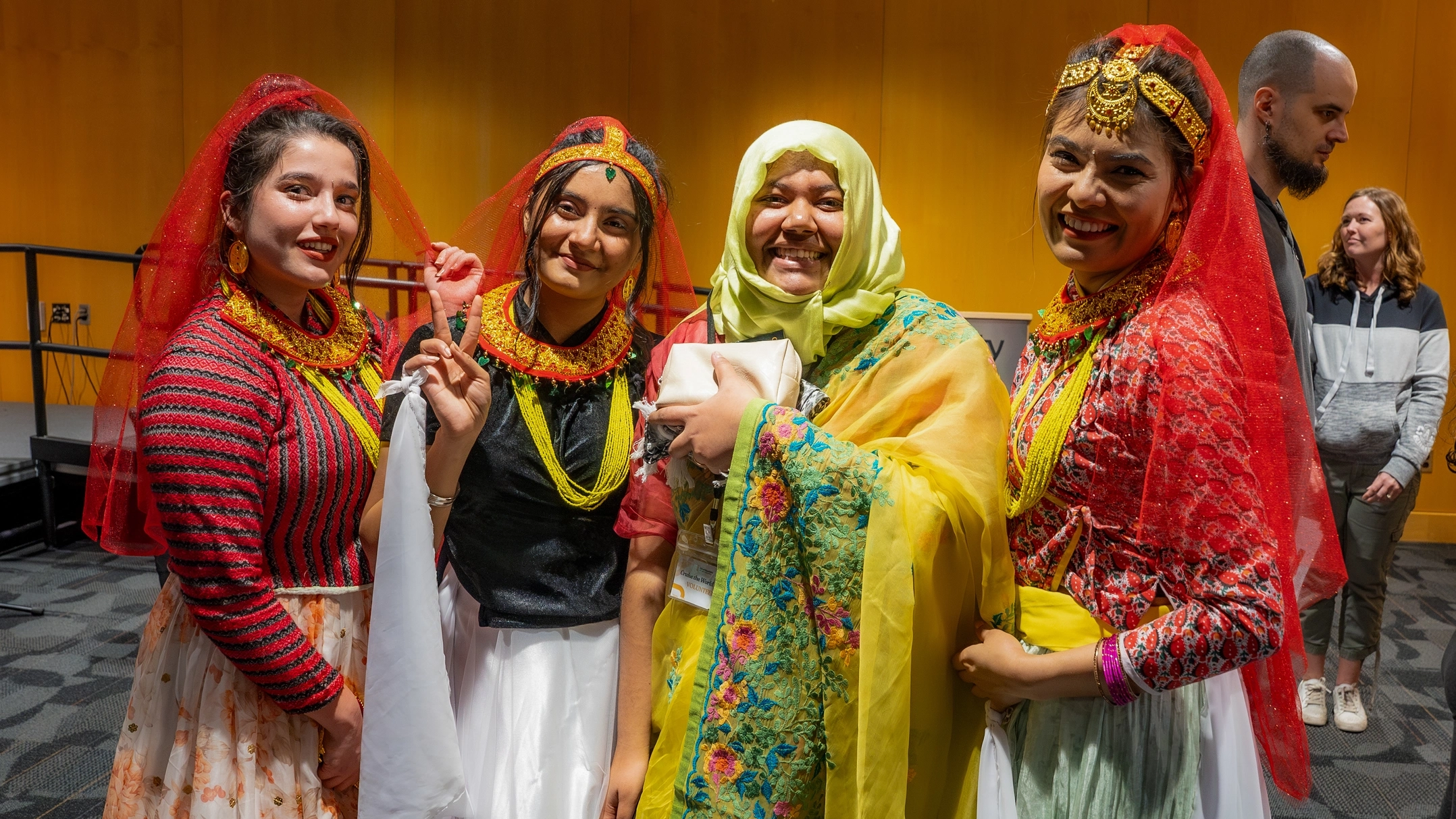 Four individuals wearing traditional costumes from their cultures