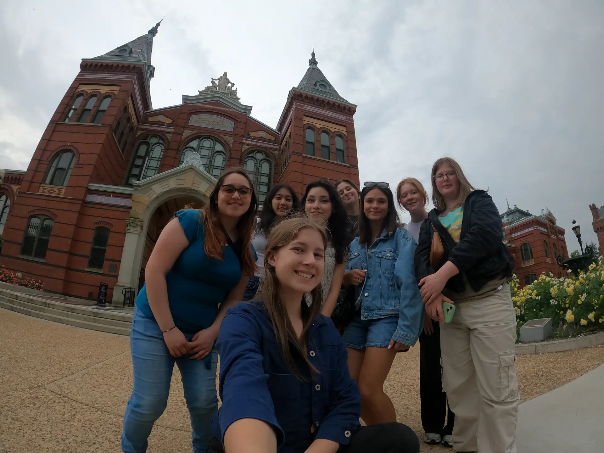 Zoë Lindner and seven other Martin Institute students pose in front of the National Museum, a red brick building.