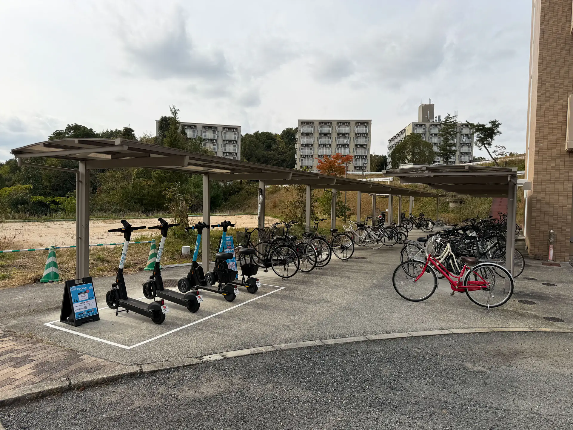 A covered parking area of bicycles and e-scooters on HU campus.