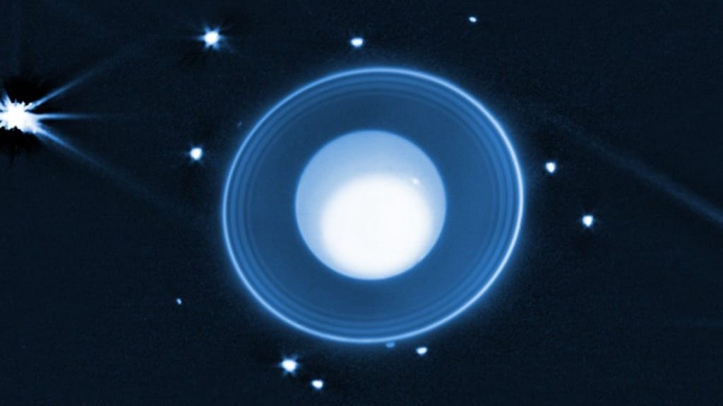 A white planet surrounded by white rings and white moons