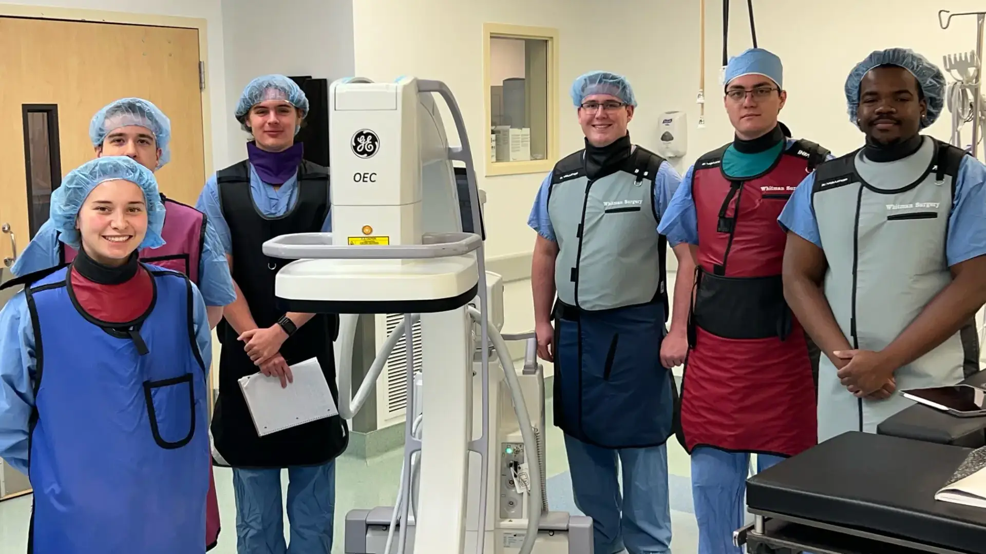 A surgical team posing with a C-arm device