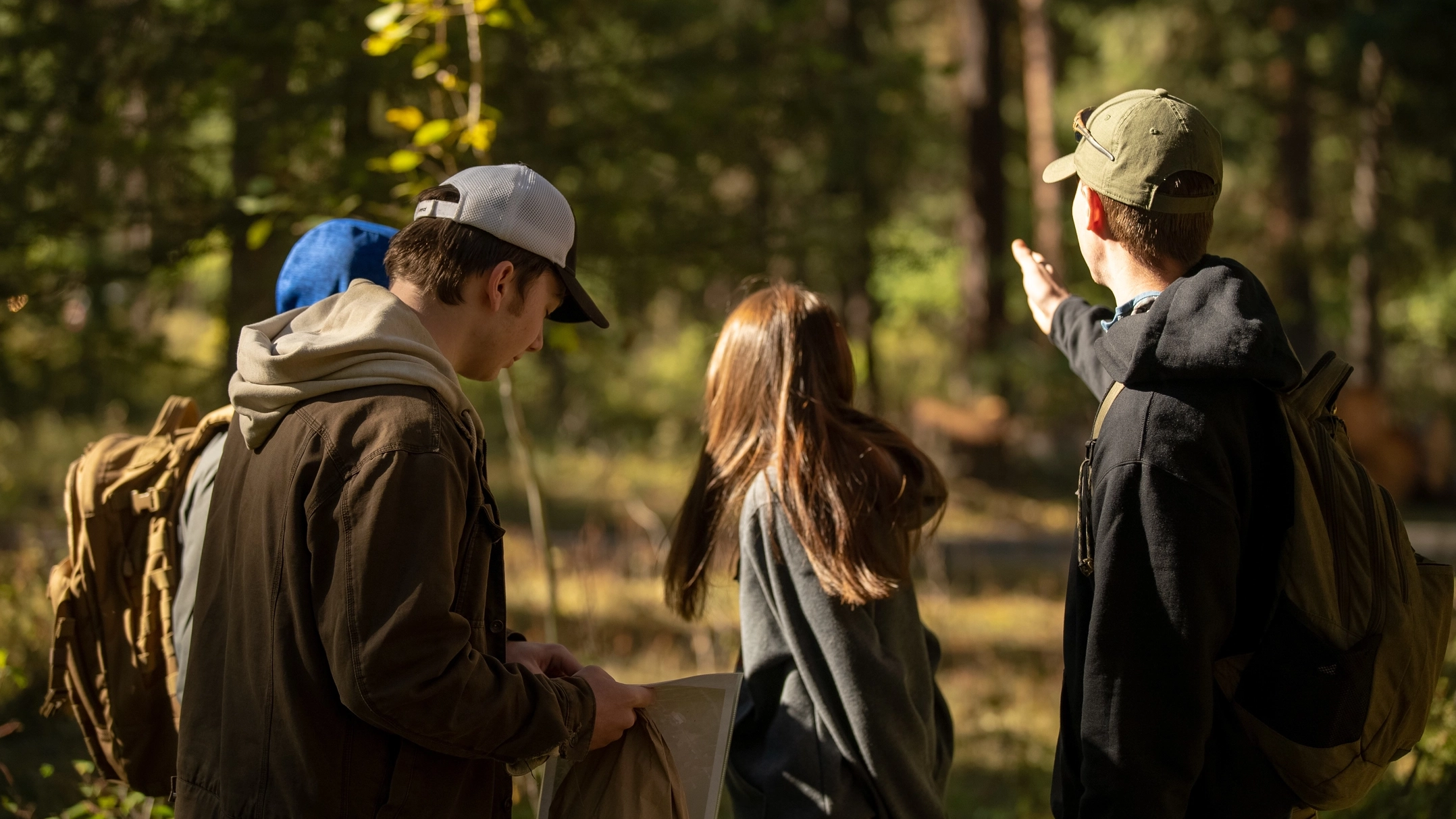 Four students look down a trail.