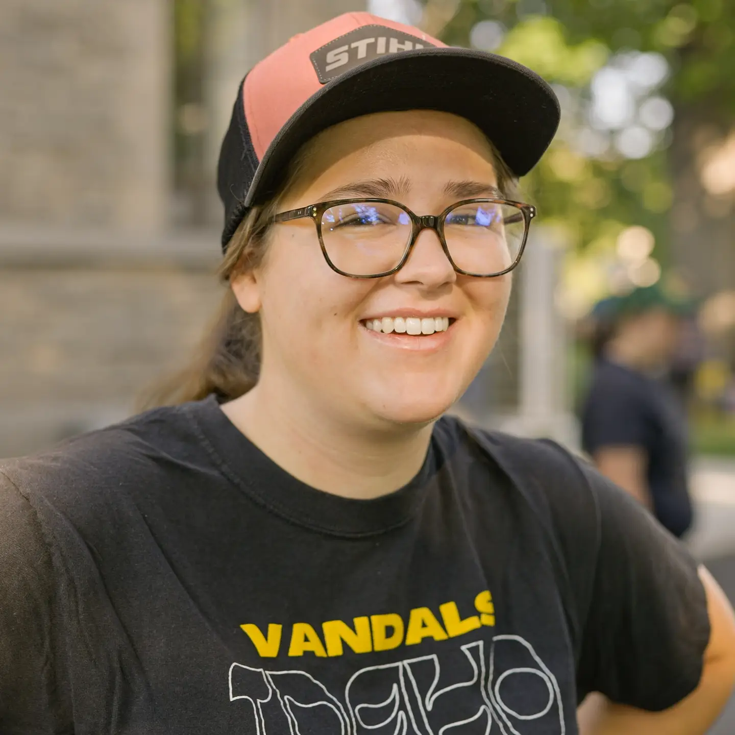 Photo of woman wearing hat and black Vandals shirt.
