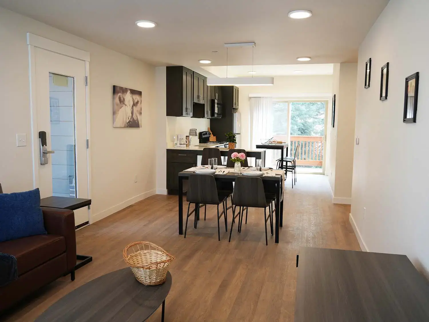 Open-concept living space in a Vandal Village Family Housing apartment showcasing the kitchen, dining area, and living room.