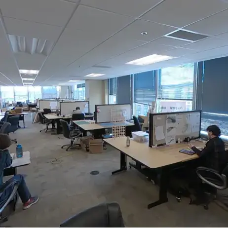 Students in room with large windows at computers with extra wide screens.