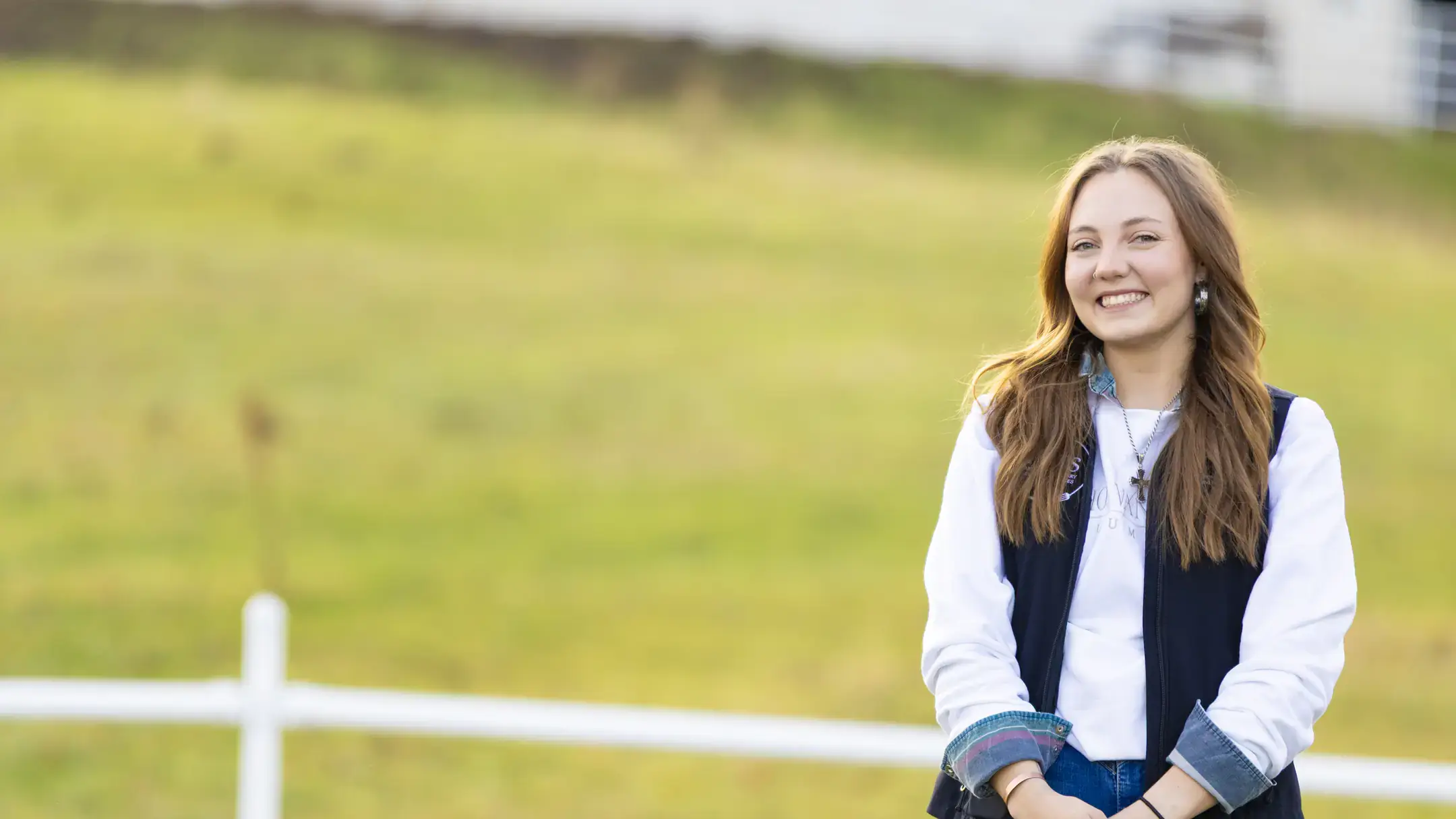 Ady Perkes poses by a fence.