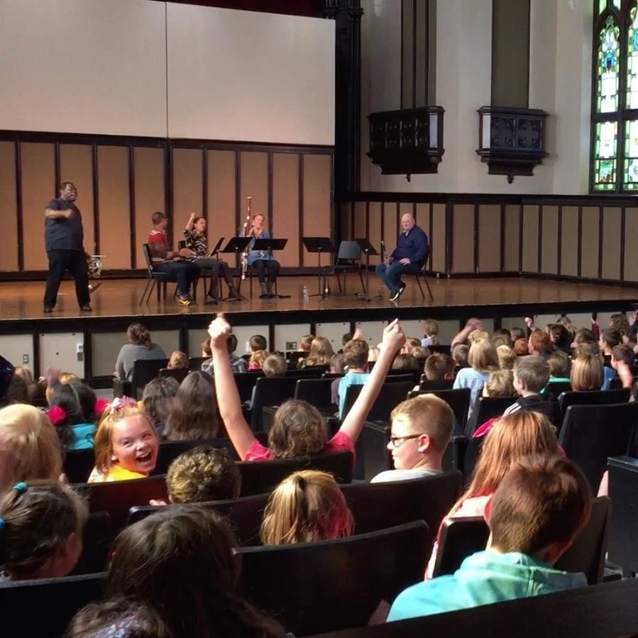 Children in auditorium cheering and listening to music