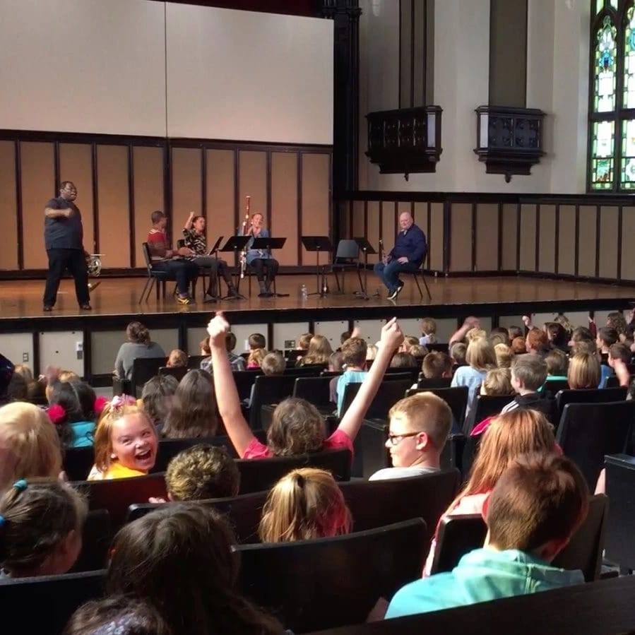 Children in auditorium cheering and listening to music